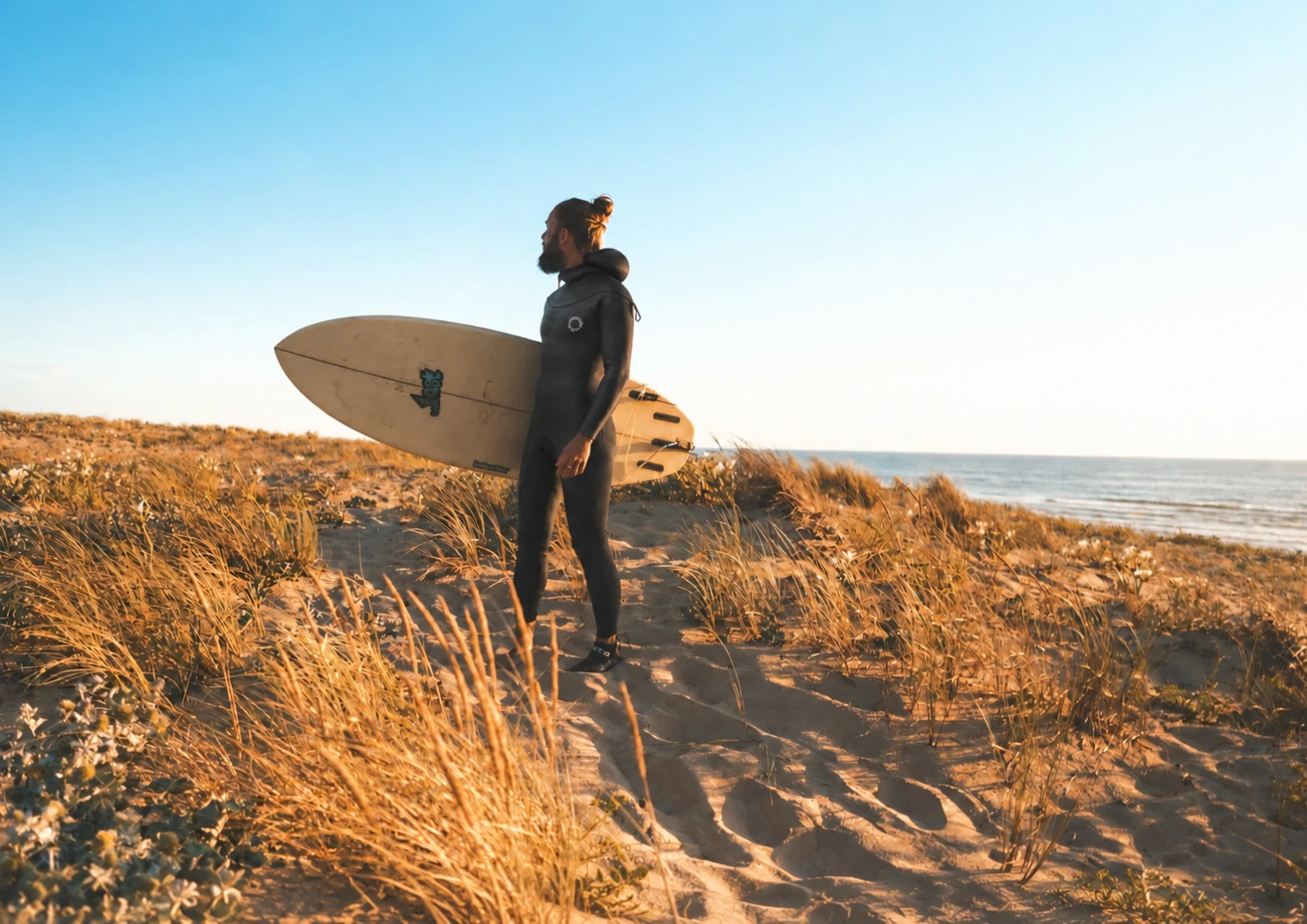 夕日の海岸でサーフボードを持つVOUCH 2026年モデル